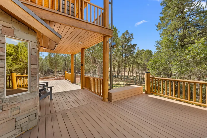 Spacious deck featuring composite flooring, wood railings, and a built-in bench