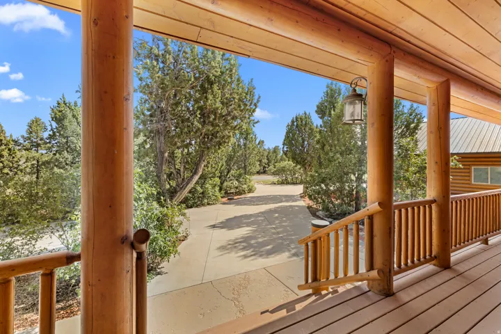Expansive log construction porch with a wood-finish floor and log railing
