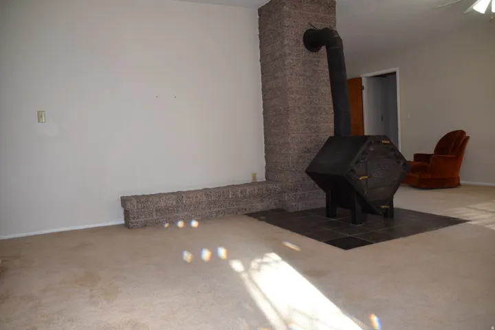 Stone-finish fireplace with a black wood-burning stove and a tiled hearth