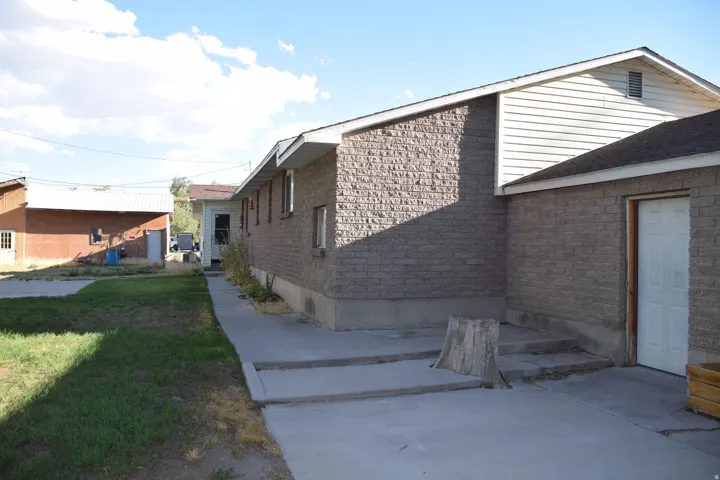 Brick exterior with white siding accents and an asphalt shingle roof