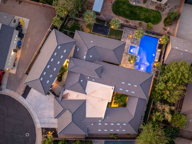 Expansive property featuring a multi-level roofline, a large swimming pool, an integrated spa, and mature landscaping