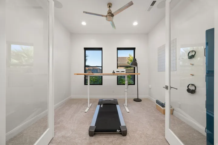 Carpeted room featuring two transom windows, recessed lighting, and a ceiling fan