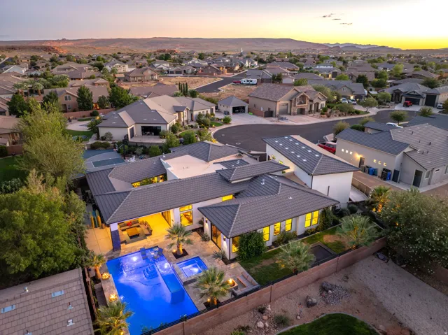Architectural residence featuring a multi-level roofline, extensive outdoor patio, integrated swimming pool with spa, and basketball court