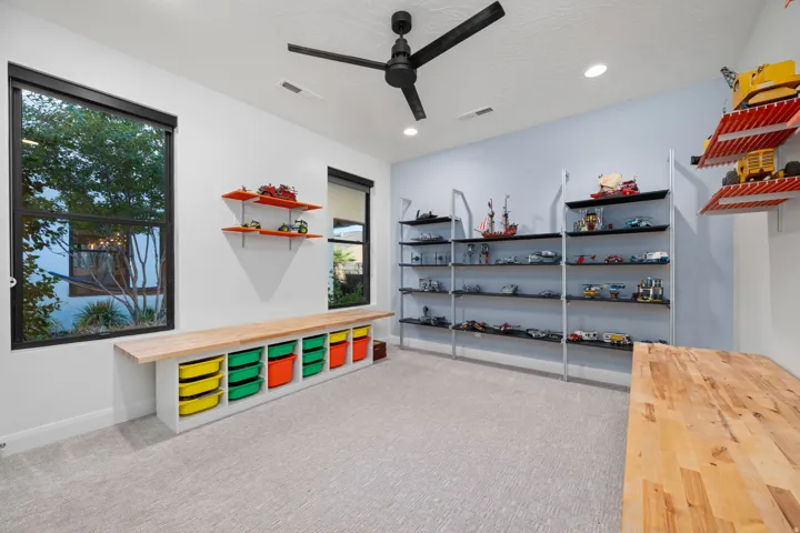 Recessed lighting throughout, black ceiling fan, dual-pane windows, built-in shelving, and light wood-finish flooring