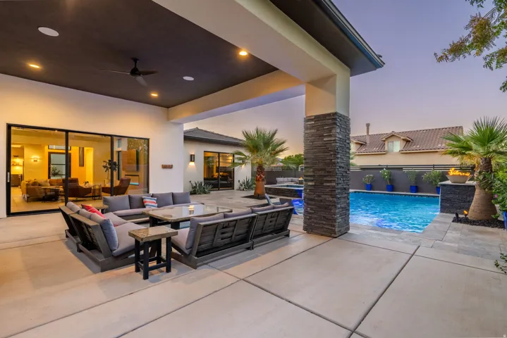 Expansive patio with a covered section, recessed lighting, and a ceiling fan