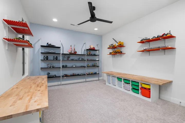 Recessed lighting illuminates the carpeted flooring and built-in shelving