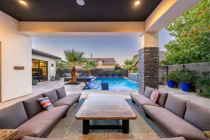 Covered outdoor patio with recessed lighting, stone veneer column, and large format tile flooring