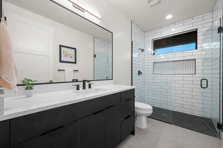 Full-length vanity with integrated sink, matte black fixtures, and a large mirror