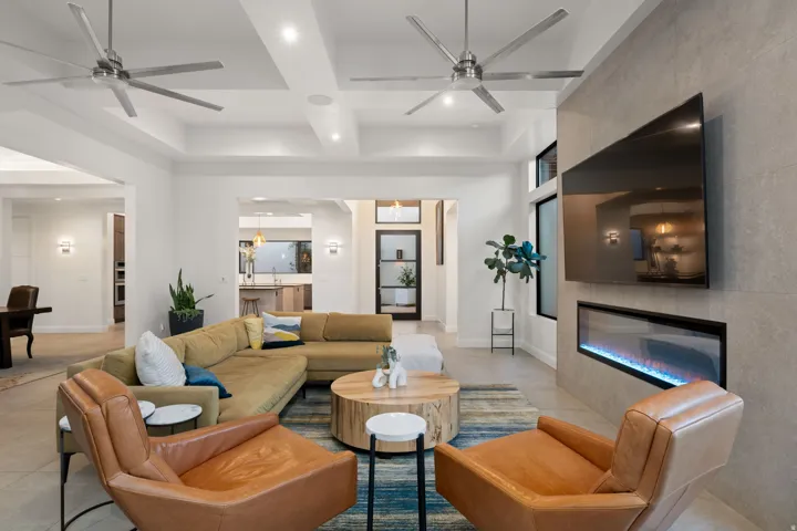 Spacious living area featuring coffered ceilings, recessed lighting, and large format tile flooring