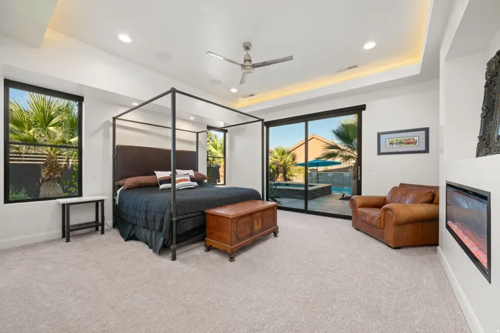 Recessed lighting, tray ceiling with ambient lighting, ceiling fan, carpeted flooring, and a built-in fireplace