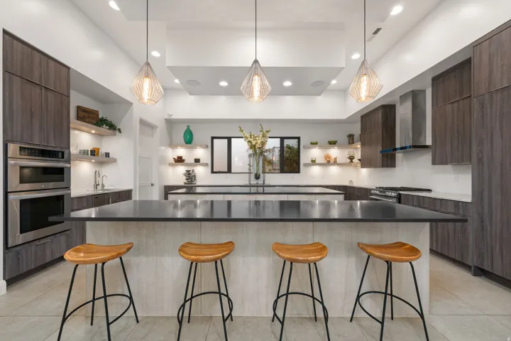 Contemporary kitchen with dark wood-finish cabinetry, stainless steel appliances, and a recessed ceiling feature