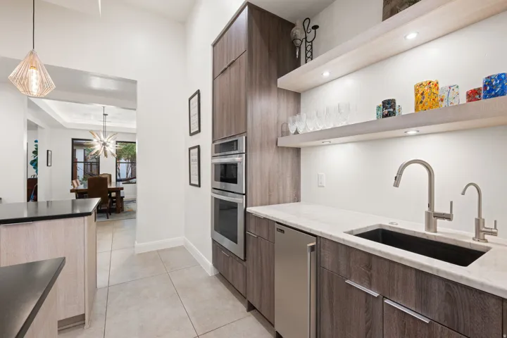 Custom cabinetry with integrated double ovens and a beverage refrigerator
