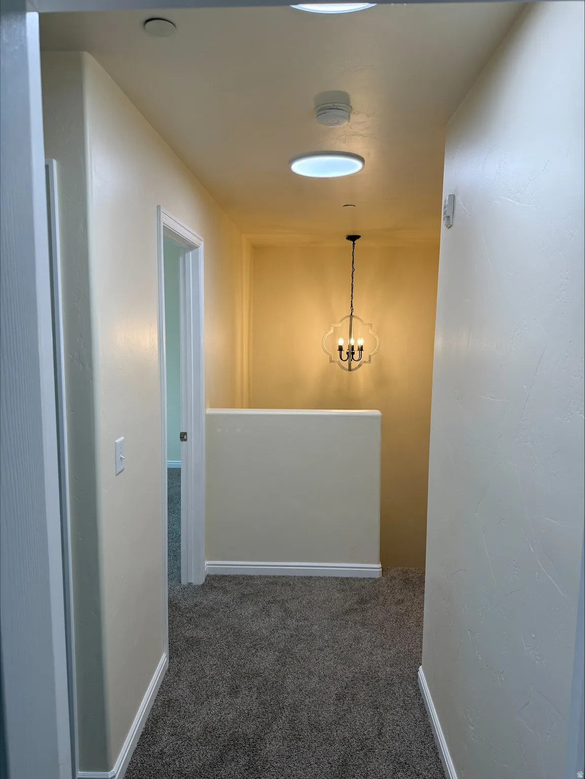 Recessed ceiling lighting, chandelier, textured carpet flooring, and white trim