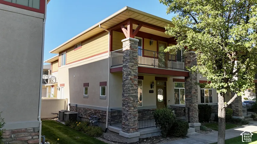 Stone-clad columns and base, exterior balcony with railing, covered porch, and horizontal siding accents