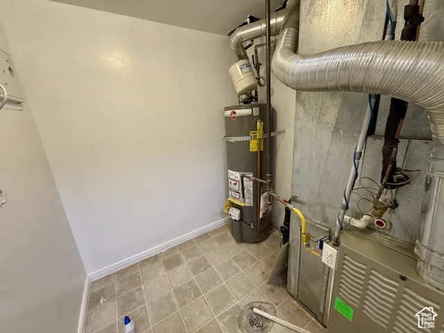 Utility space featuring a water heater and furnace unit