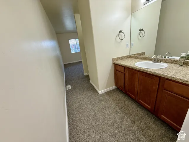 Vanity with a single basin sink, brushed nickel faucet, and a speckled countertop