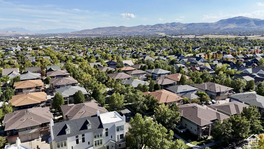 Expansive neighborhood setting with established homes and mature trees, featuring distant mountain ranges