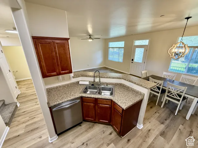 Kitchen featuring wood-finish cabinetry, stainless steel dishwasher, and granite-look countertops