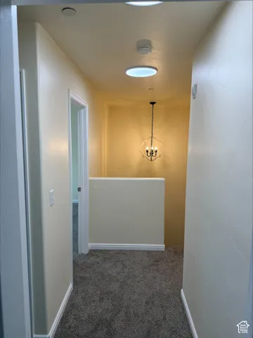 Recessed ceiling lighting, chandelier, textured carpet flooring, and white trim