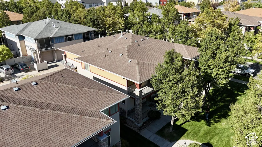 Pitched shingle roof, exterior facade with a balcony, and surrounding mature trees