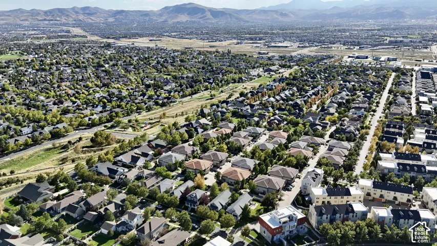Expansive residential area with a diverse mix of housing styles, established tree-lined streets, and distant mountain backdrops
