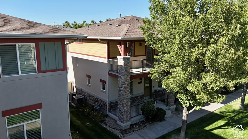 Two-story facade with stone accents, an upper-level balcony, and a covered entry