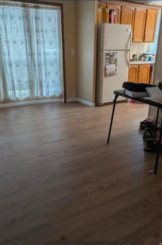 Wood-finish flooring throughout, light-toned wall paint, and natural wood cabinetry