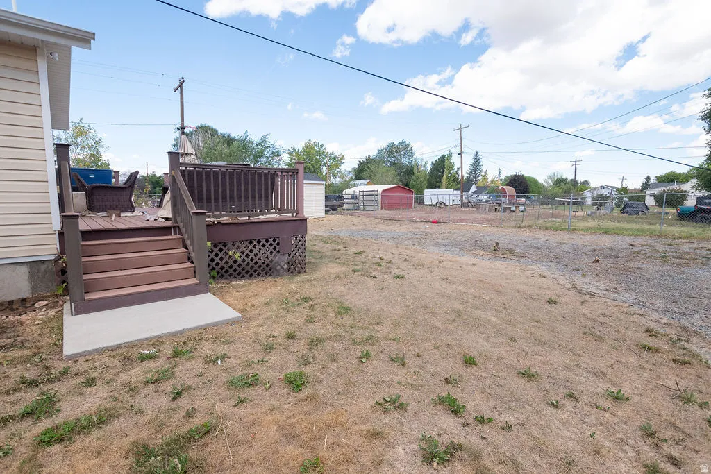 Backyard featuring a multi-level deck with railing, lattice skirting, and concrete landing