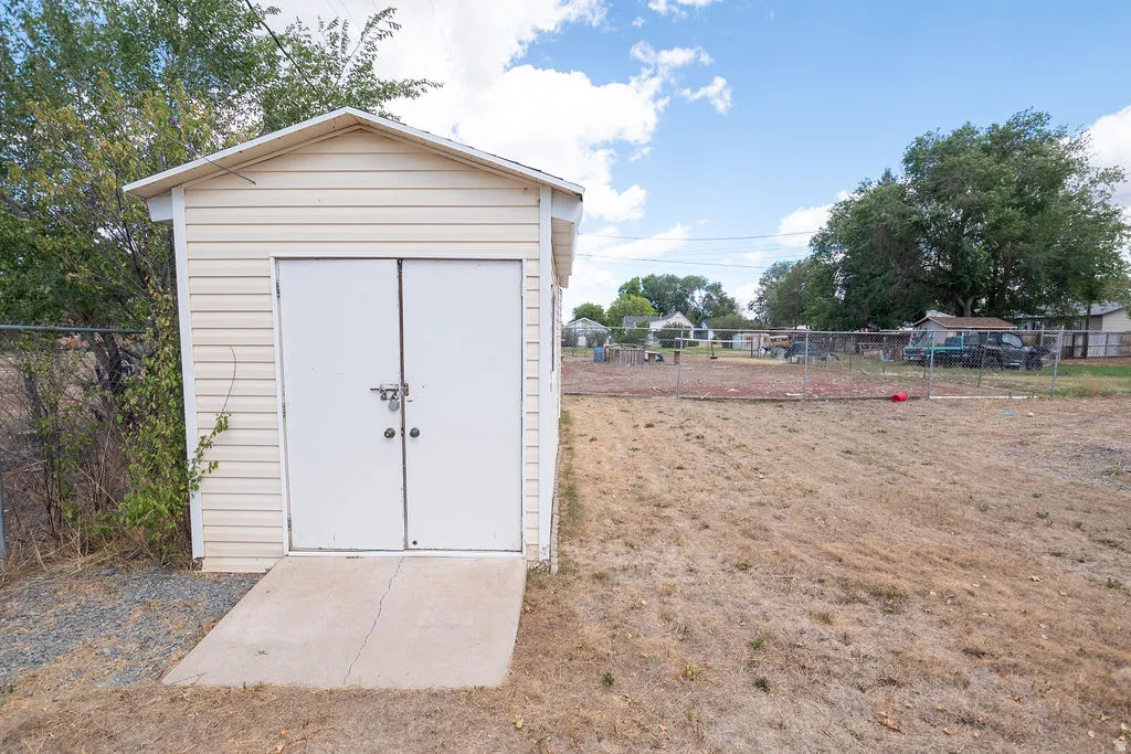 Exterior storage shed with double doors and a concrete ramp