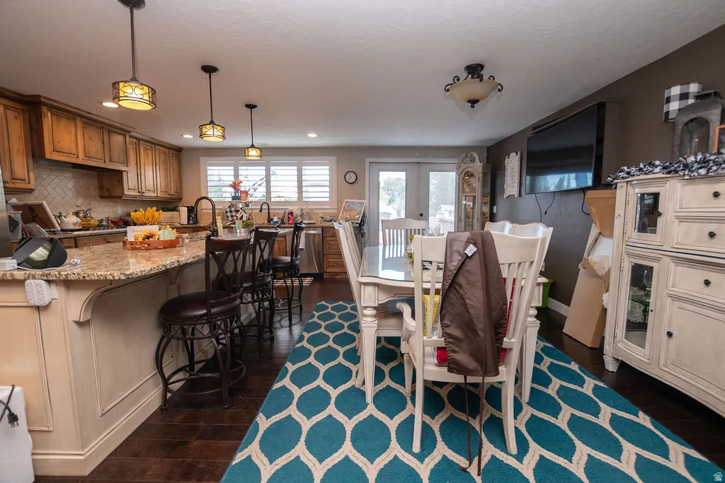 Kitchen featuring wood-finish cabinetry, granite countertops, tile backsplash, and recessed lighting