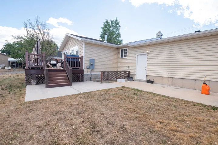 Exterior deck with steps, concrete patio, and light-colored siding