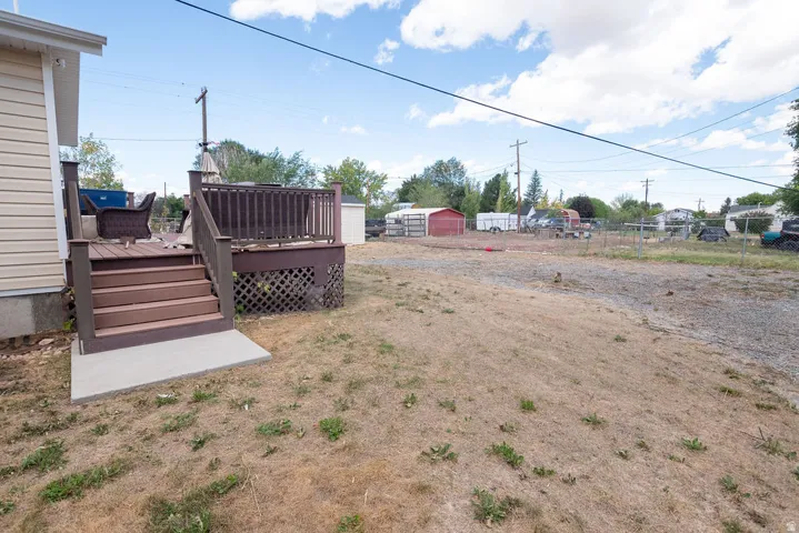 Backyard featuring a multi-level deck with railing, lattice skirting, and concrete landing