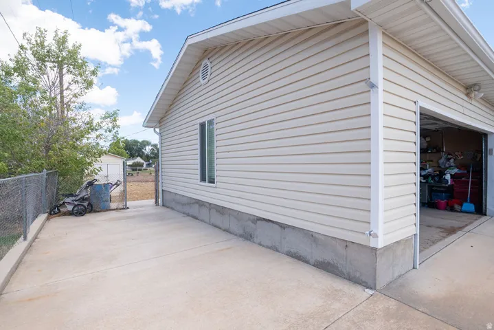 Exterior featuring light-toned horizontal siding, concrete foundation, and a single window