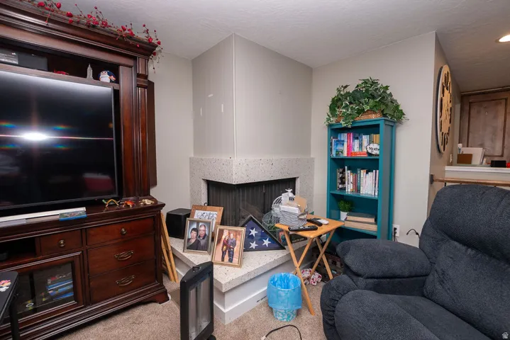 Corner fireplace featuring a light-toned hearth and mantel