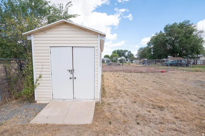 Exterior storage shed with double doors and a concrete ramp