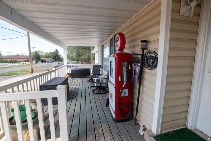 Covered front porch with wood-finish decking and white railing