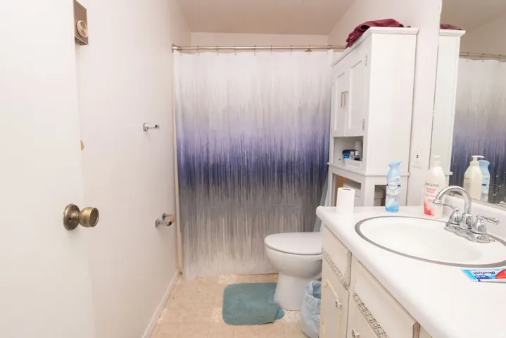 Bathroom featuring a vanity with an integrated sink, polished chrome faucet, and a wall-mounted mirror