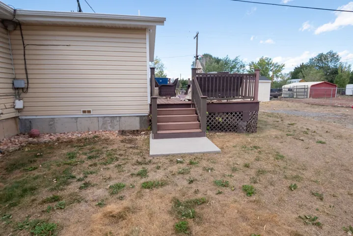 Exterior featuring horizontal siding, a raised deck with railing, and a concrete landing