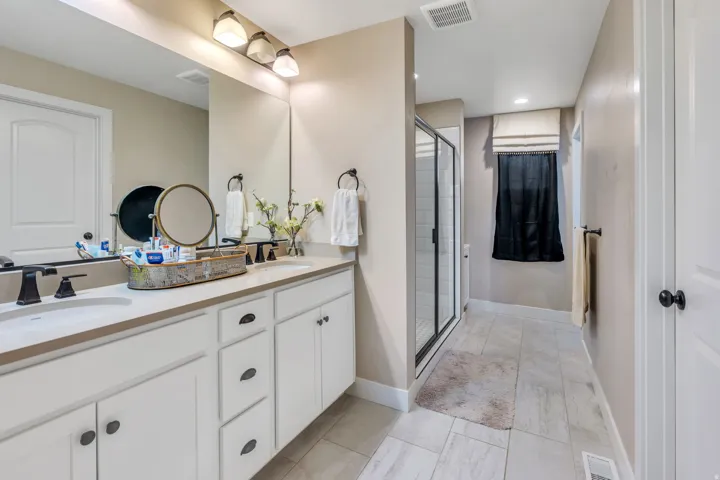 Dual vanity with undermount sinks, white cabinetry, and matte black hardware