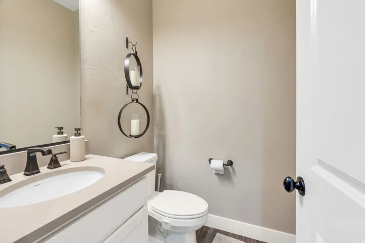 Vanity with integrated sink, bronze-finish faucet, and coordinating mirror