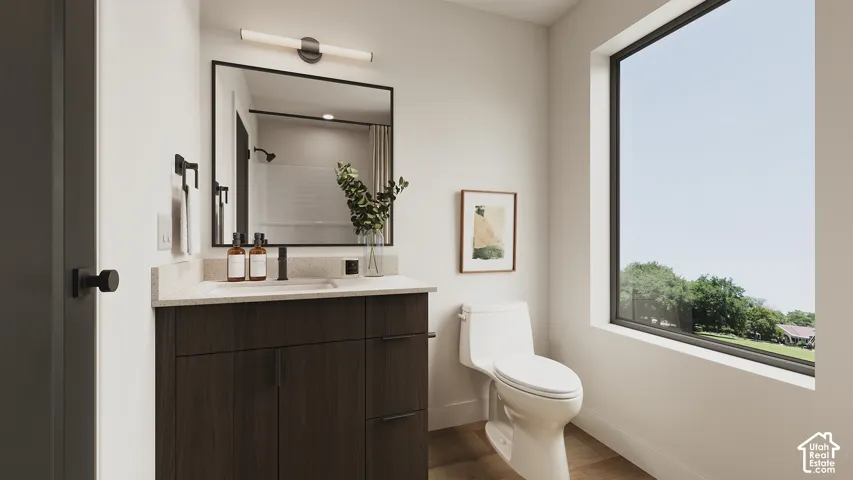 Bathroom featuring a dark wood-finish vanity with a light-toned countertop, a black-framed mirror, a modern wall-mounted light fixture, and a large window