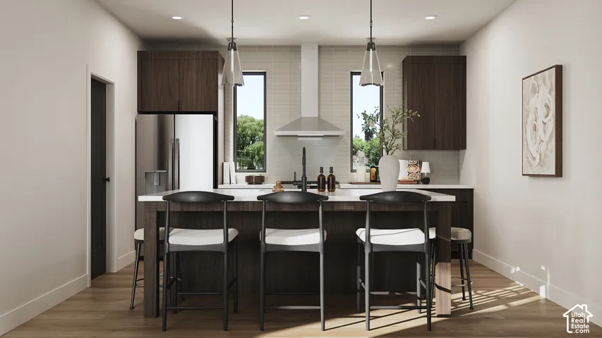 Modern kitchen featuring dark wood-finish cabinetry, stainless steel appliances, a white countertop island, and wood-finish flooring
