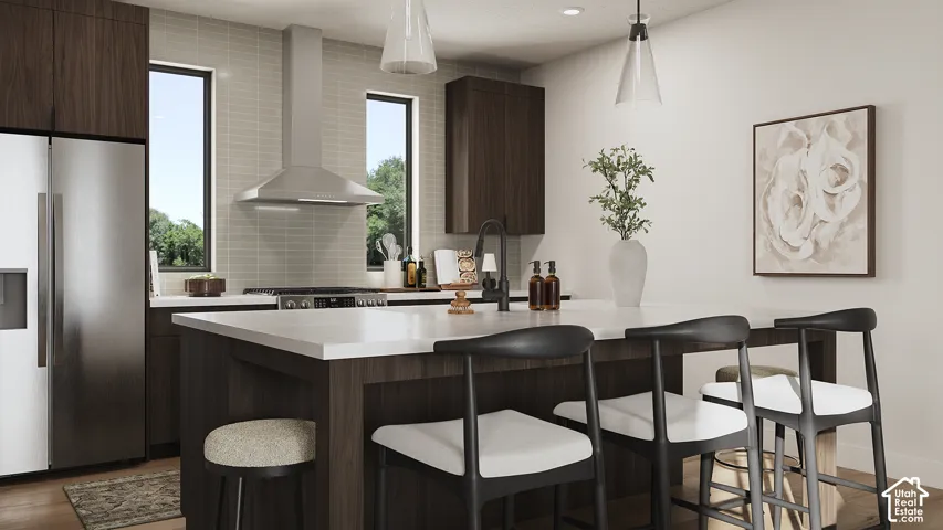 Stainless steel refrigerator, built-in range hood, light-toned subway tile backsplash, dark wood-finish cabinetry, and a central island with a white countertop