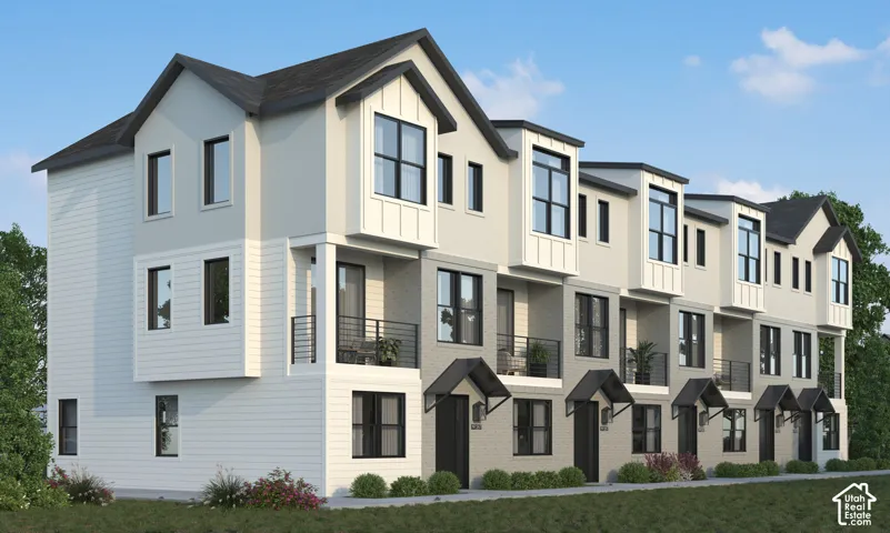 Modern multi-level townhome architecture featuring varied exterior materials, individual balconies with black railings, and decorative awnings over entryways