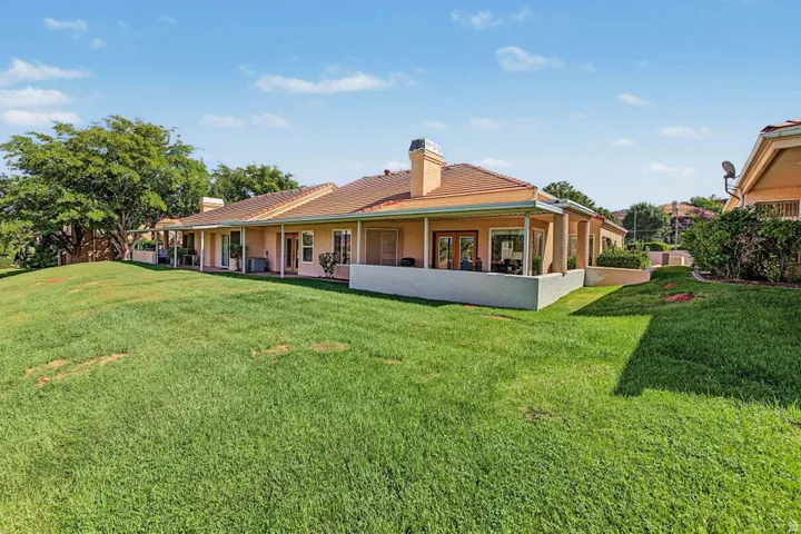 Expansive green lawn with a gentle slope and mature trees