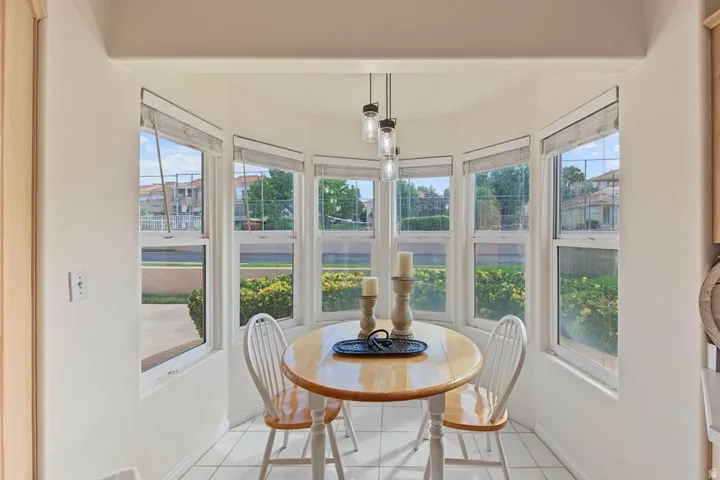 Bay window with multiple double-hung windows, suspended pendant lighting, and tiled flooring