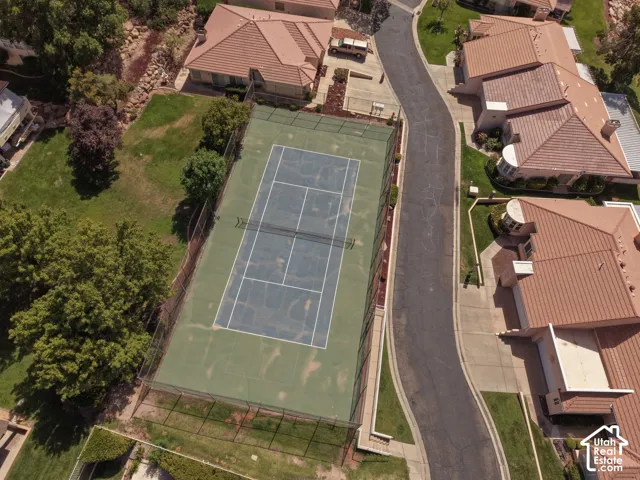 Full-size tennis court with green hardcourt surface and chain-link fencing