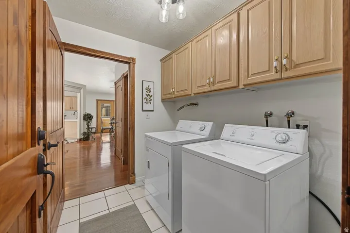 Utility area featuring tile flooring, built-in cabinetry, and wood-paneled door