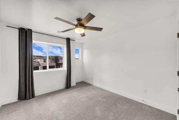 Recessed lighting, wood-finish ceiling fan, and white walls