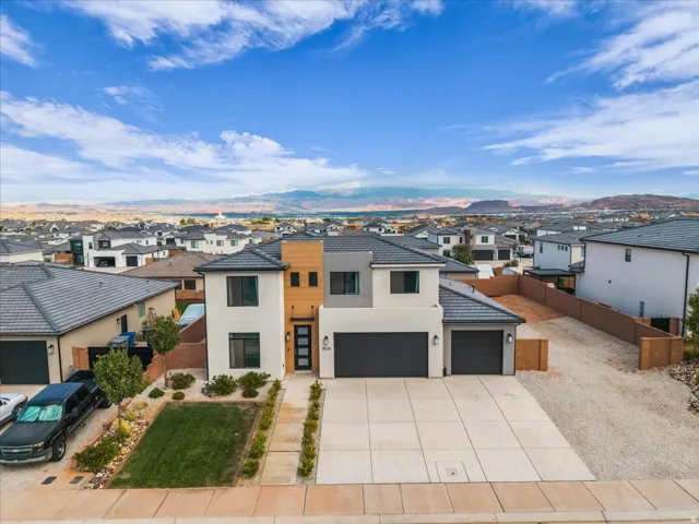 Contemporary exterior with a multi-textured facade, two-car garage, and a large concrete driveway